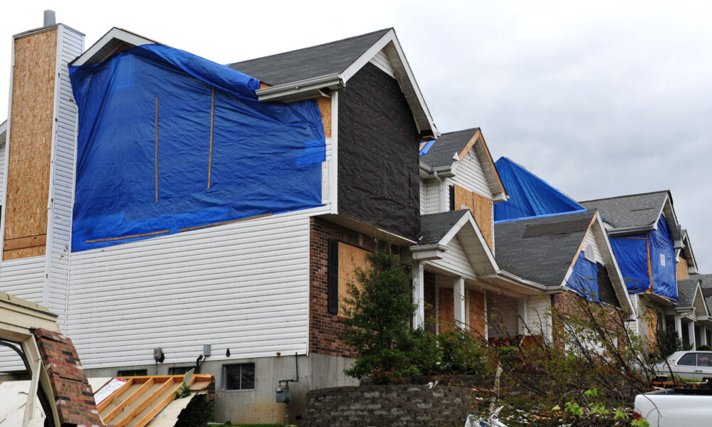 boarded up home with tarp